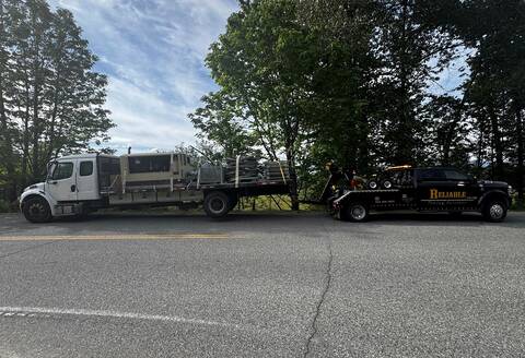 A heavy commercial vehicle being towed after its driver was stopped for speeding and impaired driving