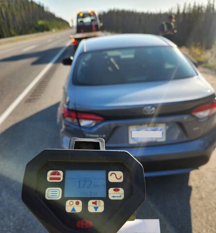 A police laser shows a reading of 172 km/h as a sedan is ready to be towed in the background
