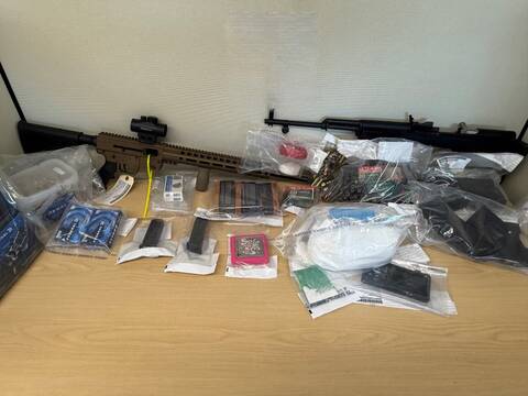 Photo of items seized including firearms, ammunitions and drugs on a table