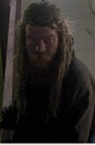 Photo of a man with long dreadlocks and facial hair