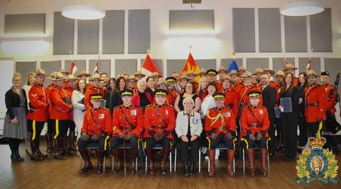 A group of RCMP officers in red serge, employees, and special guests pose for a group photo, honouring recipients of the King’s Coronation Medal in New Brunswick.