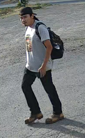 suspect male described as indigenous, 20-30 years-old with long dark hair, wearing a backwards black hat, white t-shirt, black jeans and work boots, he is carrying a backpack.