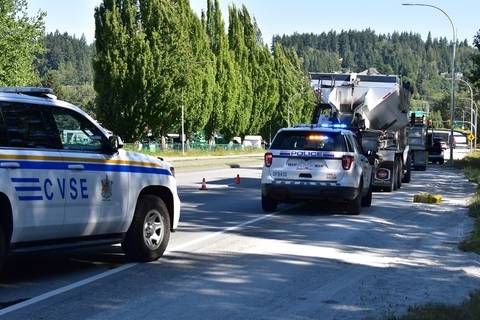 CVSE and BC Highway Patrol vehicles stopped behind two trucks getting a commercial vehicle inspection
