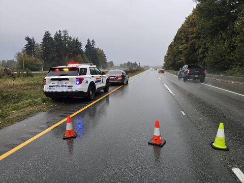 A BC Highway Patrol Patrol cruiser at roadside on Highway #1 in front of a grey Honda stopped for excessive speeding