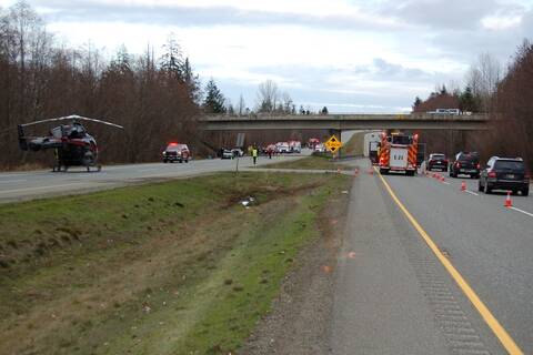 BC Highway Patrol, firefighters, and an air ambulance in the aftermath of a head-on collision involving a white pickup and a grey Toyota on Highway #19