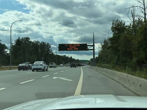 A police photo showing traffic flow under a sign displaying “BC Hwy Patrol Ahead. Drive Safe.” Moments after this photo, a prohibited driver was stopped for speeding while using his cell phone