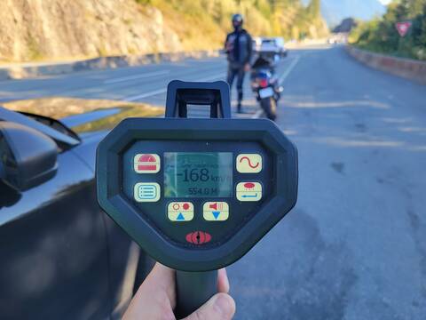 A BC Highway Patrol laser readout that shows 168 km/h while a blurred Suzuki and its rider are in the background