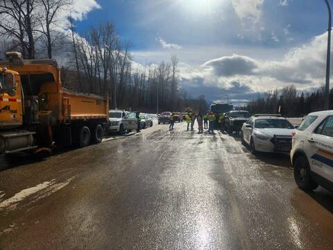 BC Highway Patrol and highway maintenance vehicles parked at the side of a road during the Slow Down, Move Over campaign