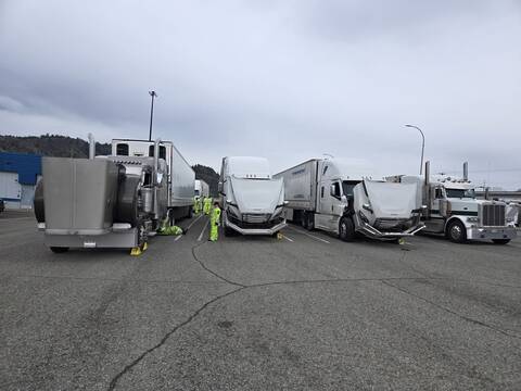 A lineup of commercial trucks with BC Highway Patrol and other examiners at a CVSA International Road Check stop near Kamloops