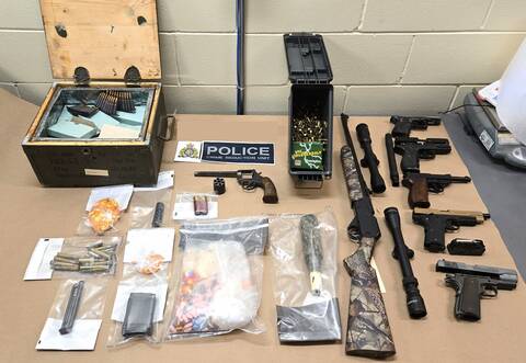 Photo of exhibits seized during the Search Warrant execution, including imitation firearms, drugs, and ammunition.