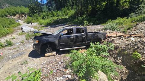 Photo of a black GMC Canyon pickup truck sitting in a small gravel pit in a wilderness area off the Lost Creek Forest Service Road.