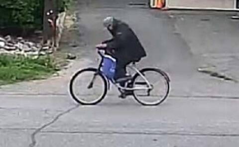 Eng: Thumbnail: Photo of man riding a white bicycle wearing black with a blue bag.