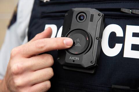 Police officer is seen wearing a body worn camera on the front of their police vest.