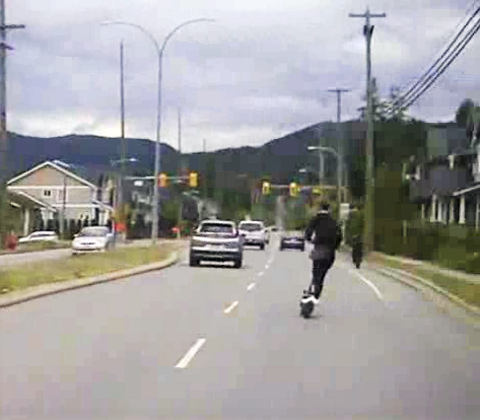 Photo of youth riding an e-scooter