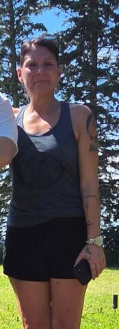 Melanie wearing a dark tank top and shorts.
