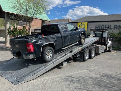 a pickup truck being loaded onto a tow truck