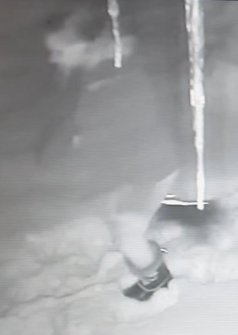 A blurry figure is shown from a still frame photo of a video surveillance tape.