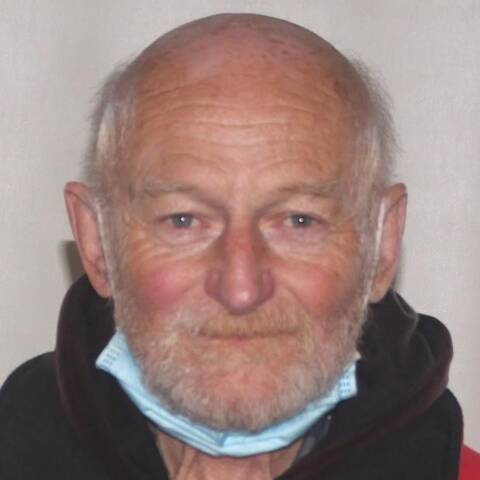 Bald male with white beard and black jacket | Un homme chauve, avec une barbe blanche et une veste noire
