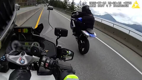A screenshot from police video that shows a motorcycle doing a wheelie on Highway #99 right in front of a police motorcycle