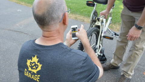Photo d’un travailleur du Projet 529 qui aide quelqu’un à enregistrer son vélo.