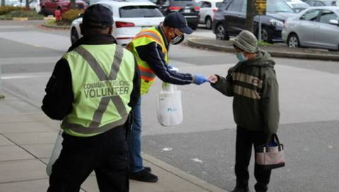 Community Policing volunteers handing out information brochures for a community outreach initiative Des bénévoles de la Police communautaire distribuent des brochures d’information dans le cadre d’une initiative de sensibilisation communautaire.